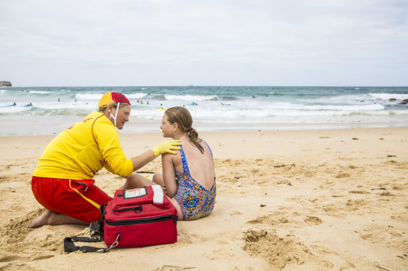 lifesaver on beach providing first aid